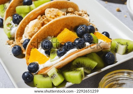 Taco Pancakes with Fresh Fruits, Blueberry and Yogurt Filling, Healthy Breakfast or Snack on Bright Background