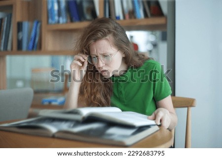 Portrait of tired overworked girl, exhausted young woman in glasses college or university student is study hard in library, prepare to exam, lesson