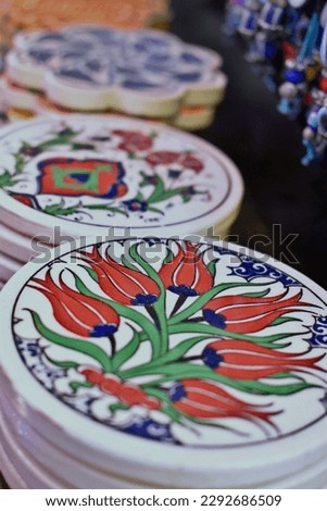 Drink Coasters. Turkish handcrafted colorful ceramic coaster with flower pattern. Stack of coasters ruby red green cobalt blue white. Round shape circular circle. Flower motif 