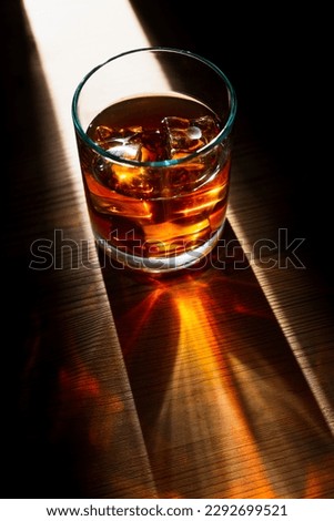Dramatic top vertical view of a glass of whiskey with ice cubes Royalty-Free Stock Photo #2292699521