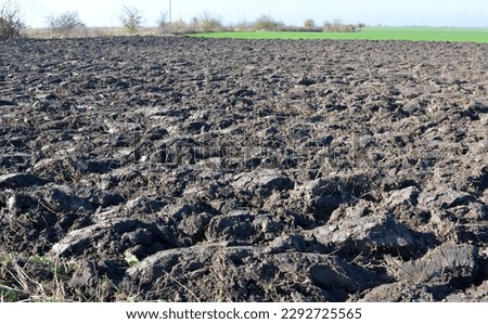 Plowing plow in autumn field with boulders of the earth