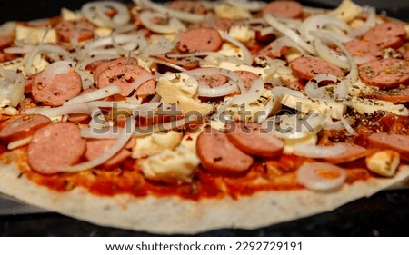 Preparing pepperoni sausage pizza with onions
