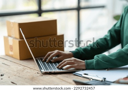 Starting a small business, SME, business owners use laptops to type communications, take orders, and check online purchase orders to prepare packages. Royalty-Free Stock Photo #2292732457