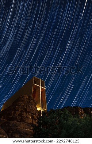 Star trails provide the background for a nighttime photo of the Chapel of the Holy Cross in Sedona, Arizona.