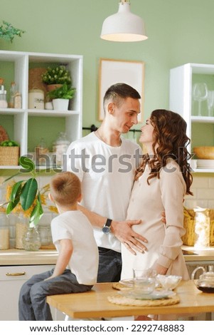 pregnant mom, son and dad In the kitchen. a loving family. the concept of family happiness. a cozy house and a mortgage for buying a house and an apartment, a loan for buying furniture and repairs.