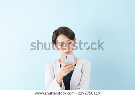 Asian businesswoman with a smartphone on blue background