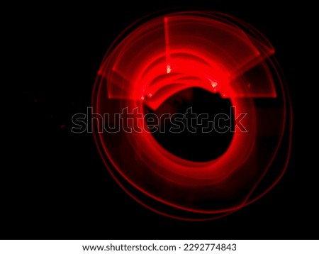 Red light painting, long exposure photography, ripples and round pattern with black background.