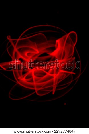 Red light painting, long exposure photography, ripples and round pattern with black background.