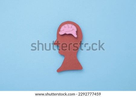 People with brains in their heads made of paper cut on blue background.