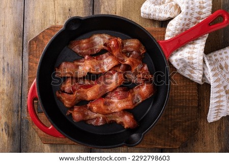 Cooked bacon in a cast iron pan, ready to eat breakfast staple Royalty-Free Stock Photo #2292798603