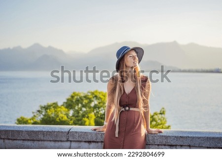 Happy woman tourist on background of Antalya sea and mountain views, sea in Turkey Antalya City. female tourist traveler discover interesting places and popular attractions and walks in the old city