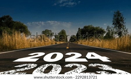 Message Year 2023 replaced by 2024 written on highway road in the middle of empty asphalt road beautiful blue sky. 
Good bye 2023 hello to 2024 happy New Year coming concept.