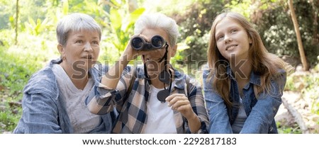 Teenager girl and two grandmother traveling travel to forest and adventure while using binoculars exploration together with happy, senior woman and granddaughter hiking with fun and vitality.