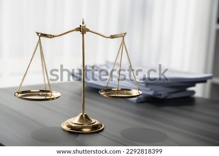 Shiny golden balanced scale and pile of legal paper on desk in lawyer office as concept justice and legal symbol. Scale balance for righteous and equality judgment by lawyer and attorney. equility Royalty-Free Stock Photo #2292818399
