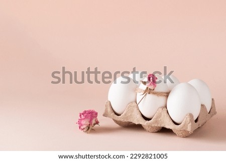 Composition with Easter eggs and eco-decor of dried roses on a beige background. happy Easter. View from above.