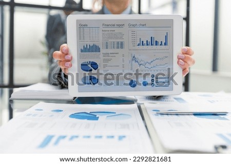 Businesswoman show tablet to display business graph.