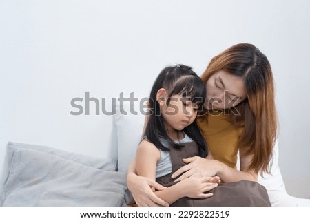 Asian mother hug her sick daughter on the bed with worry on her face Royalty-Free Stock Photo #2292822519