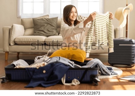 Portrait of backpacker beauty asian traveler woman packing prepare stuff and outfit clothes in suitcases travel bag luggage for summer, holiday, weekend, tourist, journey, vacation trip at home.travel Royalty-Free Stock Photo #2292822873