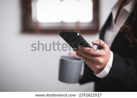 Close up of young asian confident businesswoman hand using smart phone mobile at office table working.