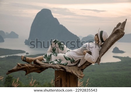 Beautiful girl on the background of mountains and the sea. Beautiful tropical nature. Dawn by the sea. Girl in white.