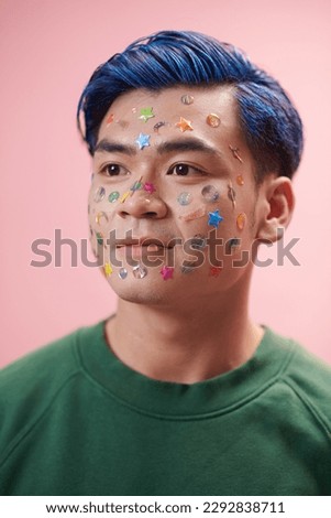 Portrait of young man with bright coloful stickers on face, self-expression concept Royalty-Free Stock Photo #2292838711