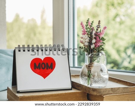 Notepad with the word MOM. Closeup, indoors. Congratulations for family, loved ones, friends and colleagues