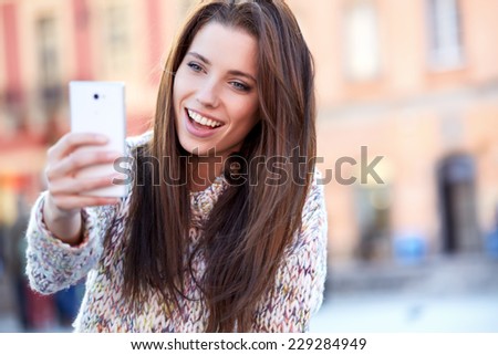 pretty young woman taking a picture on town