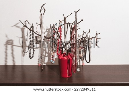 The original holder for jewelry in the form of a tree, handmade. Products with decorations on the chest of drawers. Home interior, original idea. close up