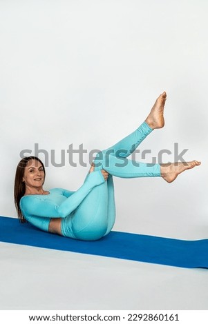 Woman in sportswear in flexible yoga pose for stretching and women's health on sports mat on white isolated background. Healthy Lifestyle. flexibility of the whole body