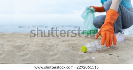 volunteering,charity,microplastic,cleaning,people picking up plastic bottle cleaning on the beach.,agriculture and climate change,microplastic waste.food industry and plastic packaging.  Royalty-Free Stock Photo #2292861515