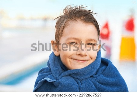 Picture of young boy in towel after playing in outdoor aqua park