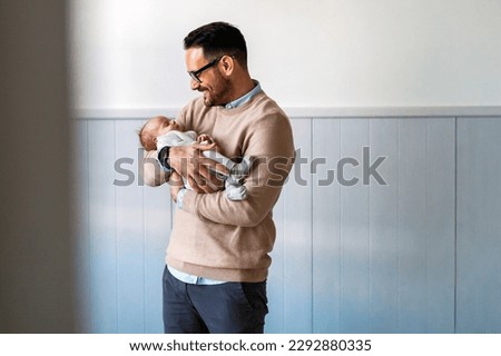 Portrait of young father holding his newborn baby. Fatherhood love single dad fathers day concept. Royalty-Free Stock Photo #2292880335