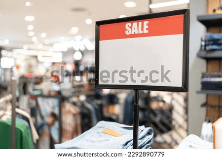 sale sign inside shopping mall. mock up advertise display frame setting over the clothes line in the shopping department store for shopping, business fashion and advertisement concept.