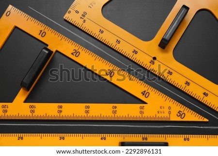Triangle, protractor, ruler and drawn acute angle on black table, flat lay