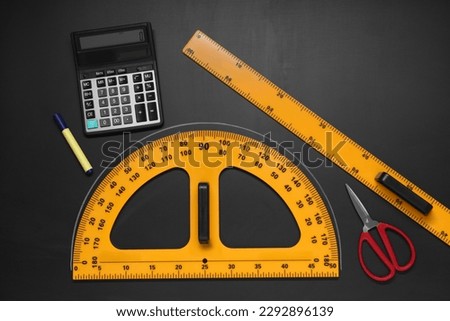 Flat lay composition with protractor and ruler on black table
