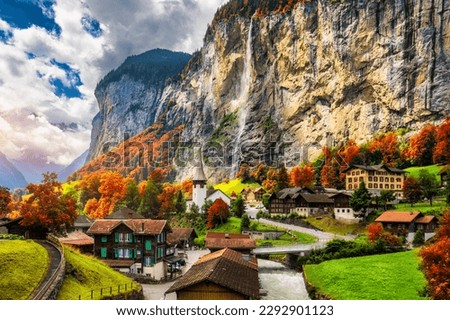 Captivating autumn view of Lauterbrunnen valley with gorgeous Staubbach waterfall and Swiss Alps at sunset time. Lauterbrunnen village with autumn red foliage, Berner Oberland, Switzerland, Europe. Royalty-Free Stock Photo #2292901123