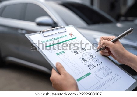 Action of a customer is signing on the agreement term of car rental service. Close-up and selective focus a human's hand with blurred background of cars in row. Business and transportation concept. Royalty-Free Stock Photo #2292903287