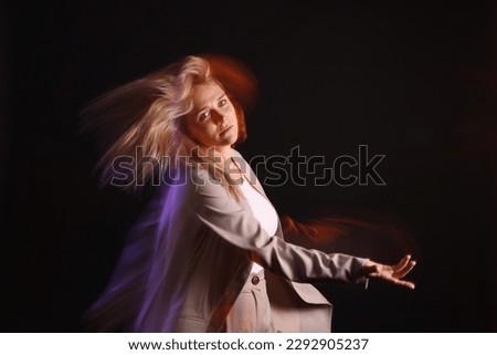 Young woman performing contemporary dance on black background, motion blur effect
