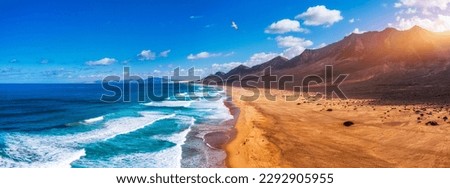 Amazing Cofete beach with endless horizon. Volcanic hills in the background and Atlantic Ocean. Cofete beach, Fuerteventura, Canary Islands, Spain. Playa de Cofete, Fuerteventura, Canary Islands. Royalty-Free Stock Photo #2292905955