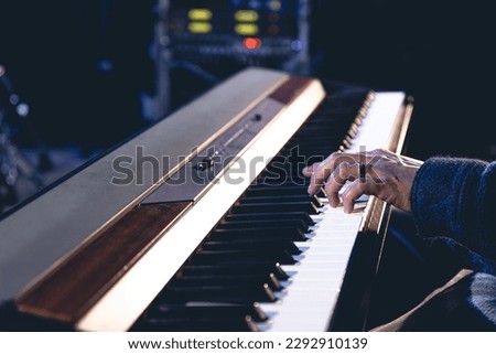 A man plays the electronic piano, hands close-up.