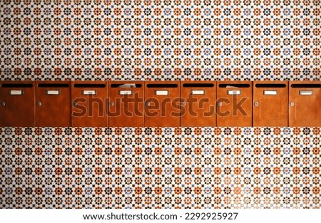 Mailboxes for letters at the entrance of the residential building of a community of neighbors with a background of geometric tiles of Andalusian style, Spain Royalty-Free Stock Photo #2292925927