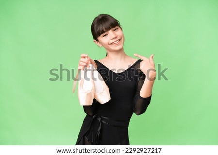 Little caucasian girl practicing ballet over isolated background giving a thumbs up gesture