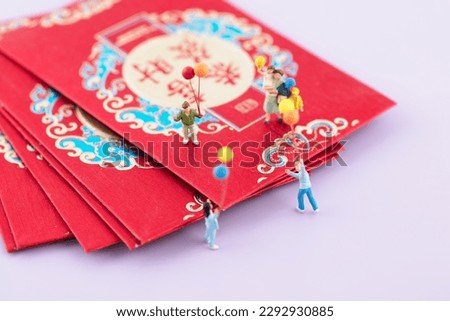 Miniature photography provides children with red envelopes for festive occasions.The Chinese characters in the picture mean: "Congratulations on getting rich"