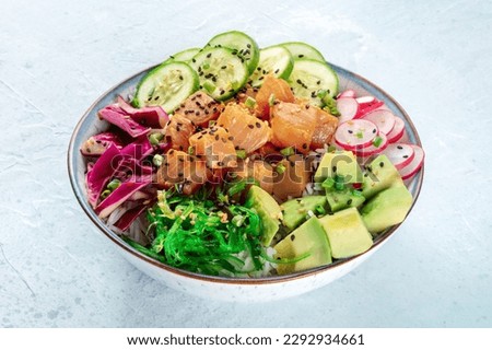 Tuna poke bowl with avocado, cucumbers, wakame, radish, and purple cabbage, a healthy pescatarian diet dish with rice Royalty-Free Stock Photo #2292934661