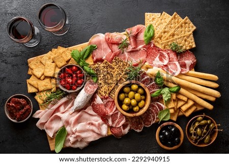 Appetizers with differents antipasti, charcuterie, snacks and red wine. Sausage, ham, tapas, olives and crackers for buffet party. Top view, flat lay Royalty-Free Stock Photo #2292940915