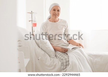Mature woman after chemotherapy reading book in clinic Royalty-Free Stock Photo #2292944465