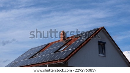 view to the roof of a building with a chimney and photovoltaic solar panels Royalty-Free Stock Photo #2292960839