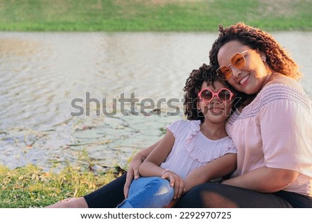 Hispanic Mother With Their Daughter Enjoying Picnic