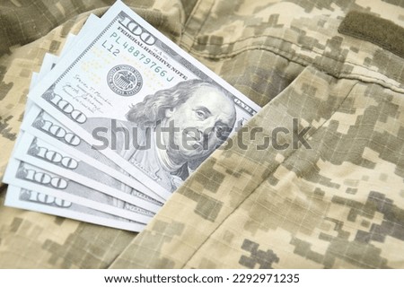 American dollars banknotes on military pixel background. The concept of wages, payments and donations to the military.