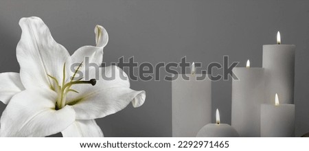 Funeral. White lily and burning candles on grey background, banner design Royalty-Free Stock Photo #2292971465
